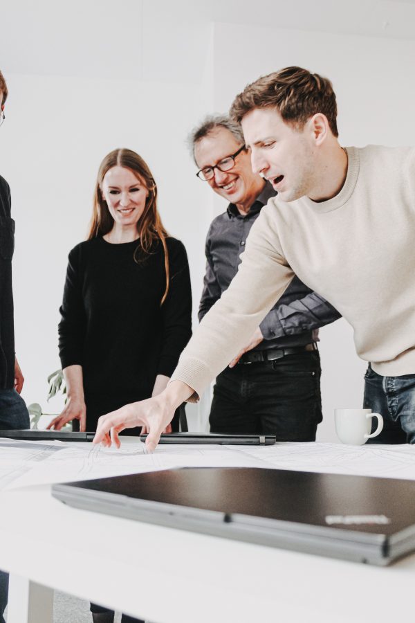 Three team members discussing project plans at a table.